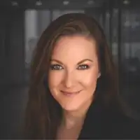 Kaitlynn Sommers, a woman with long brown hair and a faint smile against a dark blurred background